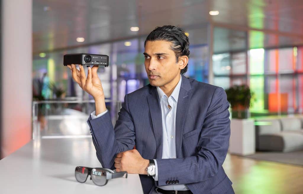 Ein Mann hält die VR-Brille von Vodafone und den dazu gehörigen Mini-Computer