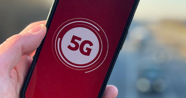 5G-Symbol auf Hintergrund in Vodafone-Rot auf Display eines Smartphones, das in einer Hand gehalten wird