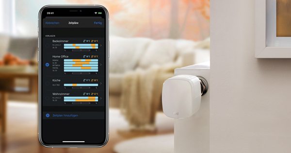 Handy mit Heizungs-App neben Heizkörperthermostat als Symbolbild für die besten smarten Thermostate