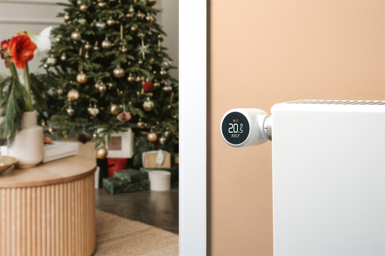 Tado Smartes Heizkörperthermostat X neben einem Weihnachtsbaum an die Heizung montiert