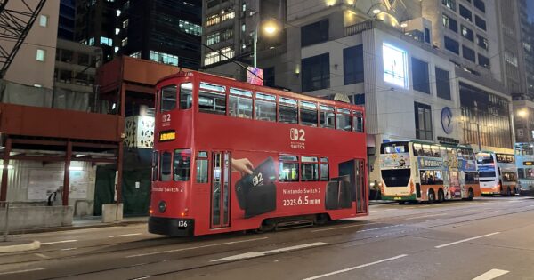 Eine Doppelstock-Straßenbahn in Hong Kong mit roter Switch-2-Werbung.