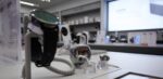 Blick in den Xiaomi-Store im Hintergrund mit Nahaufnahme auf eine Smartwatch und ein Ohrhörer-Case (freigestellt).