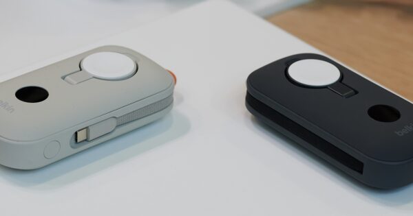 Zwei der Powerbanks ausgestellt in schwarzer und heller Sandfarbe mit sichtbarem Apple-Watch-Lader eingeklappt..