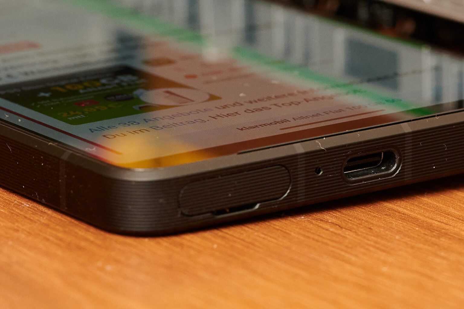 Smartphone liegt auf dem Rücken. Sichtbarer USB-C-Anschluss und Klappe für SIM- und SD-Karte.