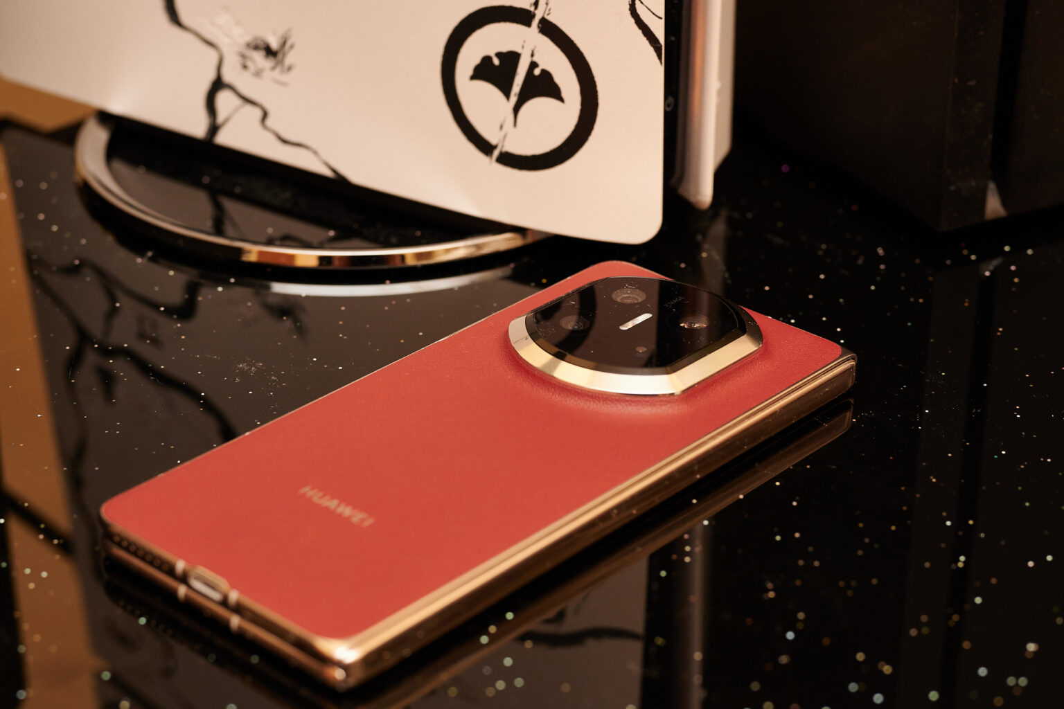 Huawei Mate X7 (Rot) vor einer PS5, Rückseite sichtbar.