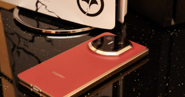 Huawei Mate X7 (Rot) vor einer PS5, Rückseite sichtbar.