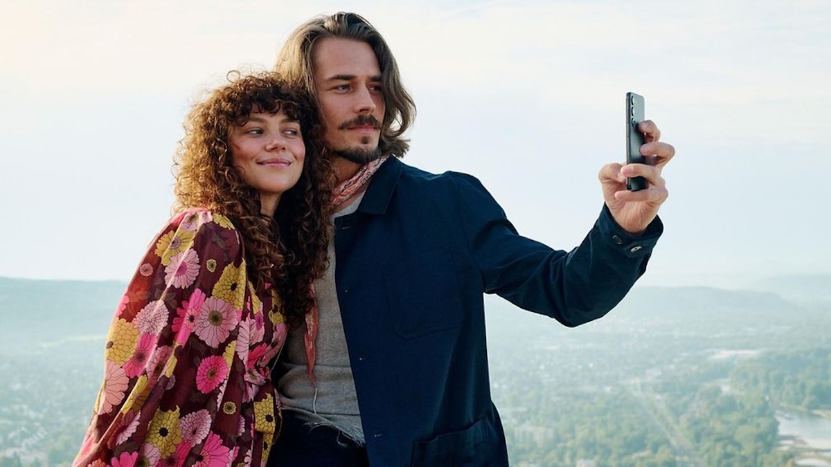 Frau und Mann machen gemeinsam ein Selfie vor einem Landschaftshintergrund