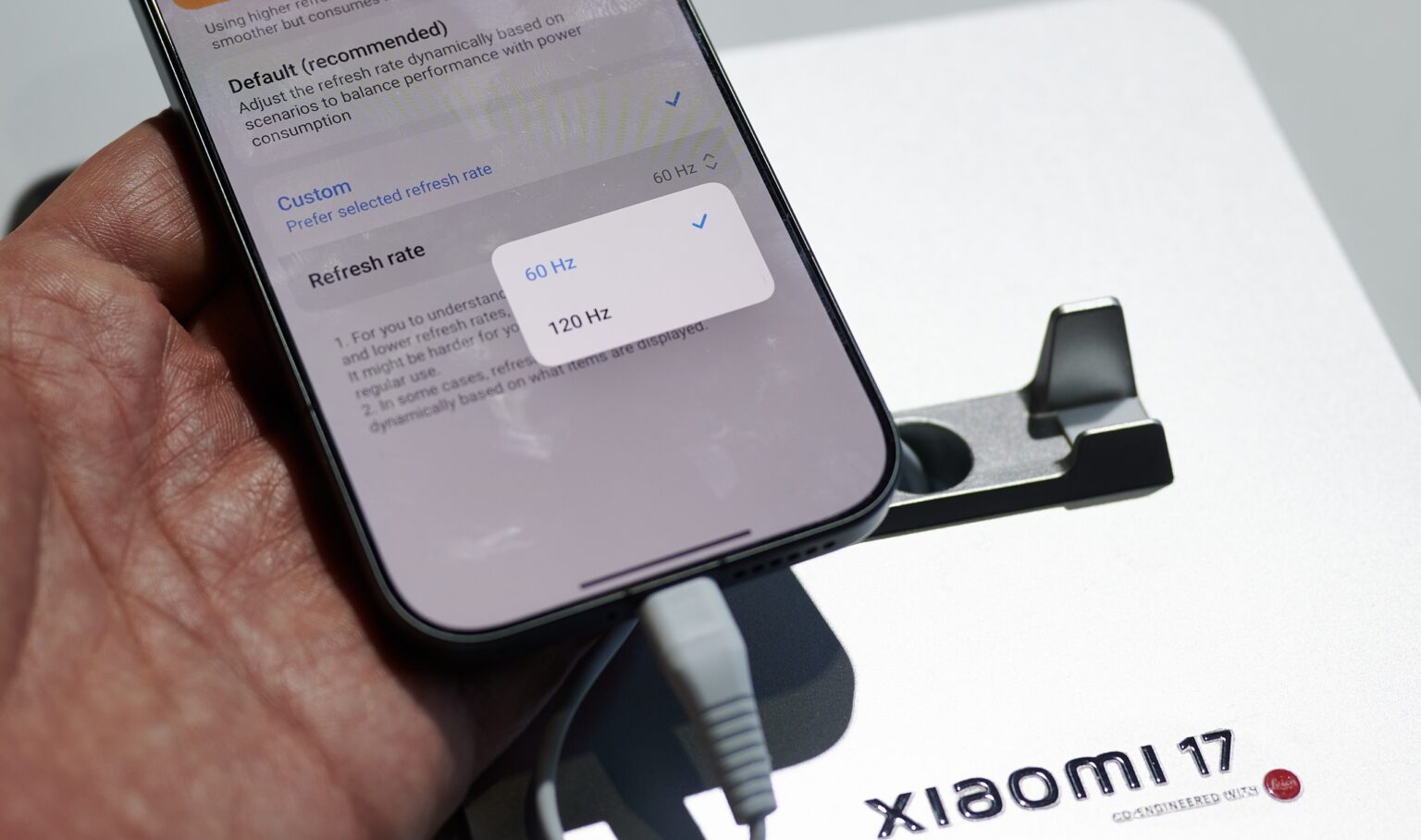 In der hand gehaltenes Xiaomi 17 mit offenen Display-Einstellungen und zwei Hertz-Angaben.