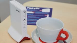 Fritzbox neben einer Tasse für einen Größenvergleich.