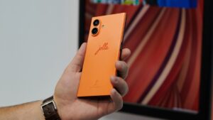 Jolla Phone in Orange in der Hand gehalten. Rückseite, mit Schriftzug.