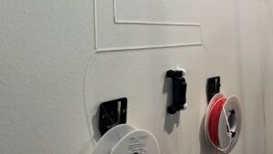 Demoinstallation mit Kabelkanal und Kabel. Unten zwei Rollen für Kanal und Kabel.Mitte: Ein "Rennauto" zum Eindrücken der Glasfaser.