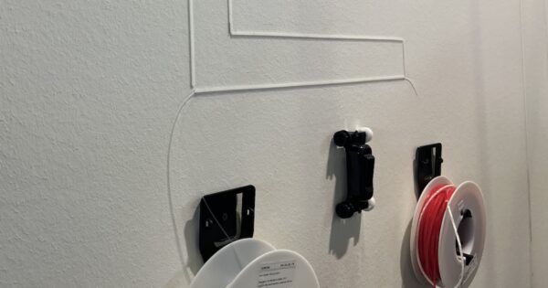 Demoinstallation mit Kabelkanal und Kabel. Unten zwei Rollen für Kanal und Kabel.Mitte: Ein "Rennauto" zum Eindrücken der Glasfaser.