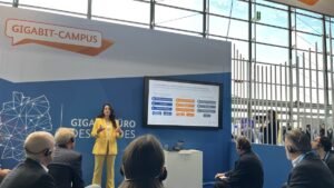 Vortragssituation mit Bildschirm, Folien und Zuschauern.