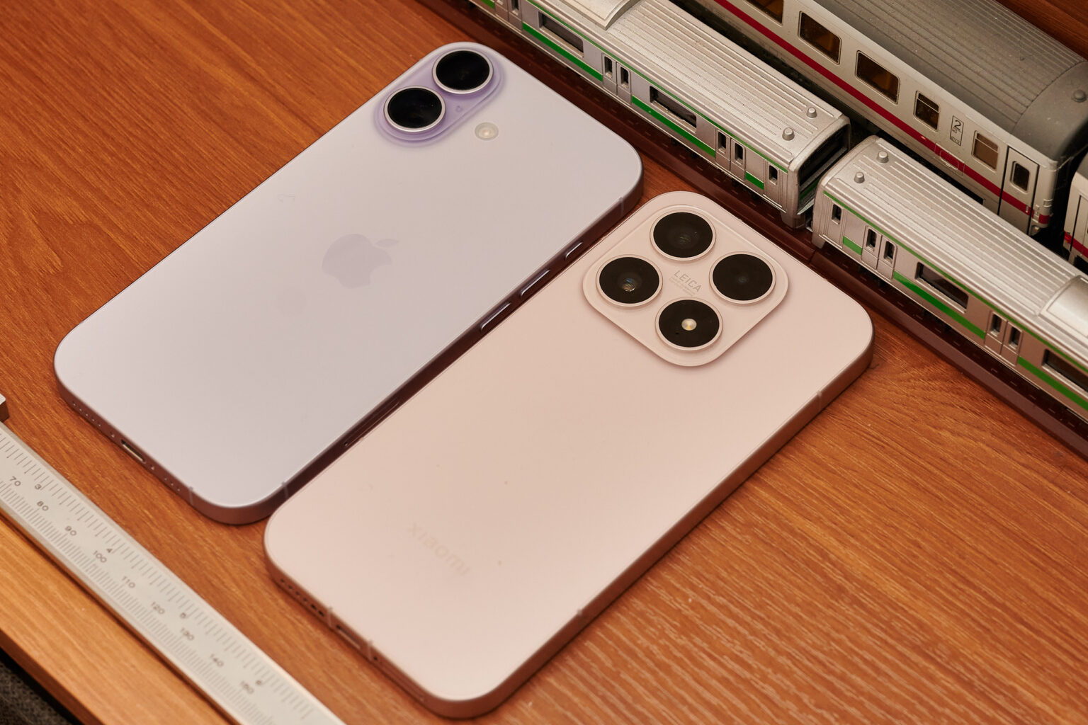 iPhone 17 und Xiaomi 17 nebeneinander auf einem Tisch mit Messschieber dadrunter.