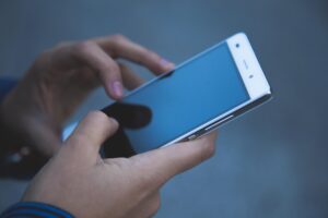 Symbolbild Smartphone in der Hand dunkles Display News Teaser
