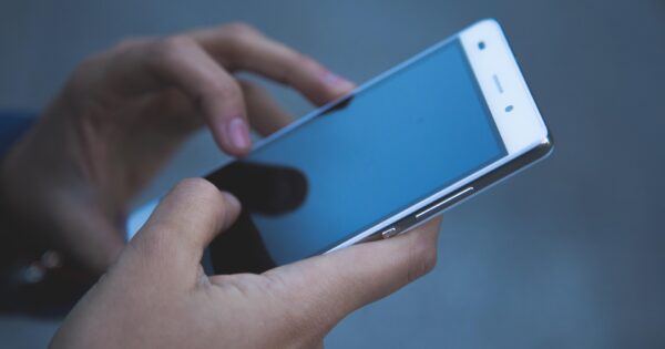 Symbolbild Smartphone in der Hand dunkles Display News Teaser